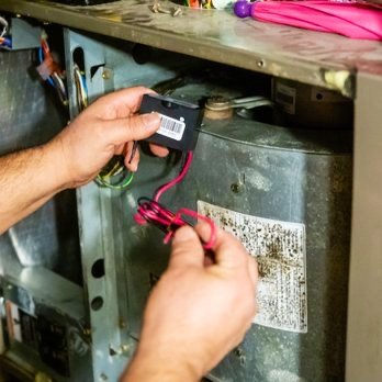 HVAC technician servicing unit in Dallas Fort Worth TX